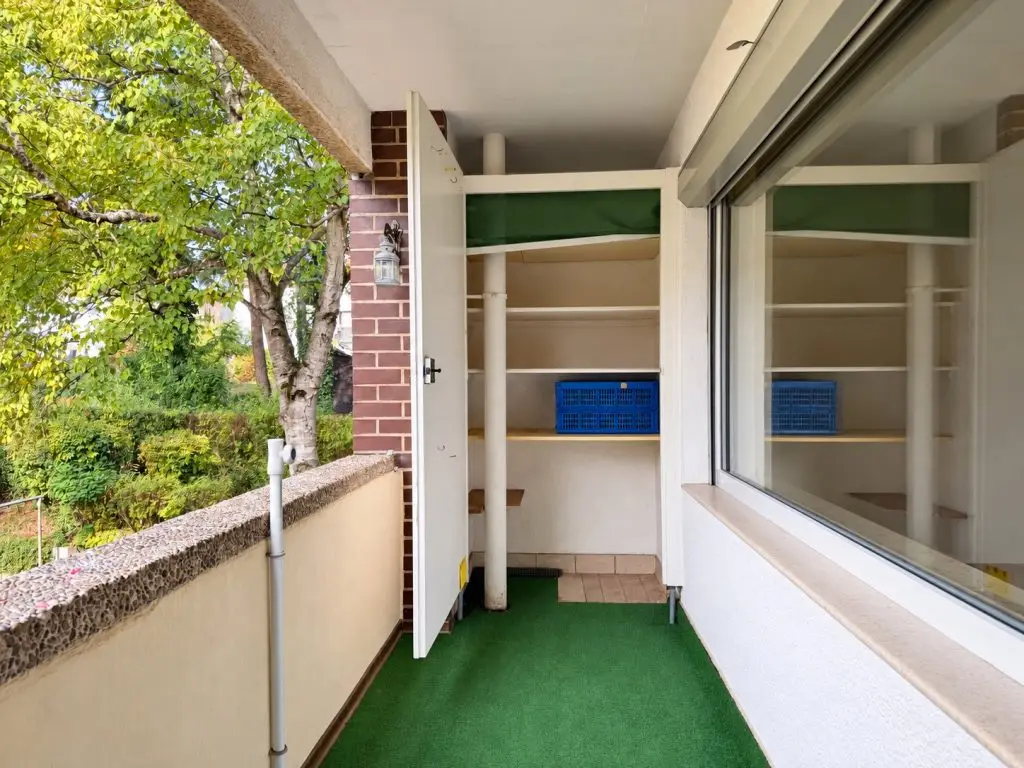 Überdachter Balkon mit praktischem Abstellraum und Blick ins Grüne